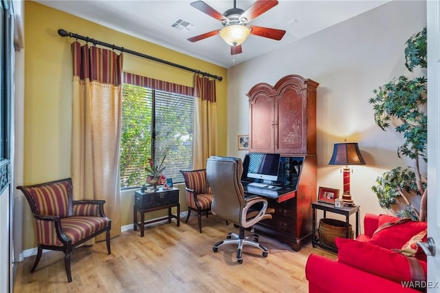 home office with baseboards, a ceiling fan, visible vents, and light wood-style floors