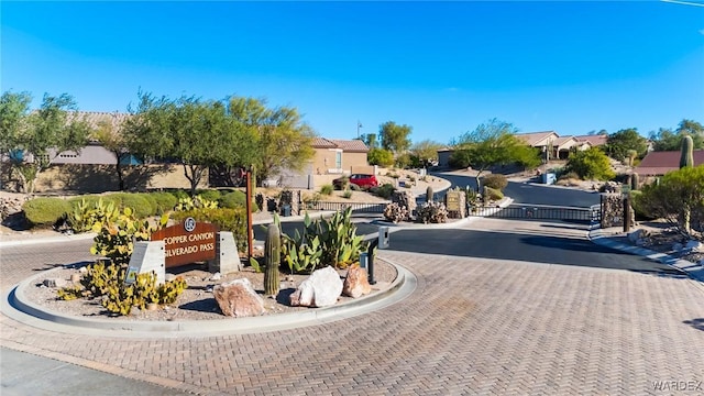 view of street with curbs, a gate, and a residential view