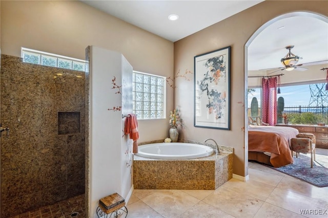 full bathroom with ceiling fan, a walk in shower, a bath, tile patterned floors, and ensuite bath