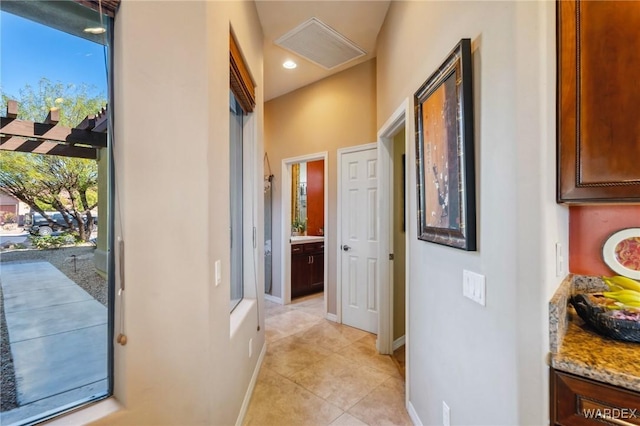 hallway featuring light tile patterned floors, baseboards, visible vents, and recessed lighting