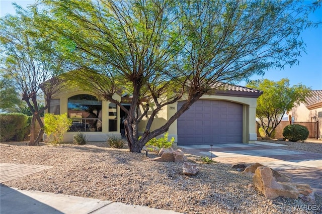 view of front of house featuring a tiled roof, concrete driveway, and stucco siding