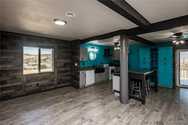 kitchen with white appliances, visible vents, dark countertops, ceiling fan, and light wood-style flooring