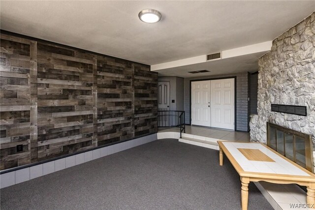 interior space with carpet floors, a fireplace, and visible vents