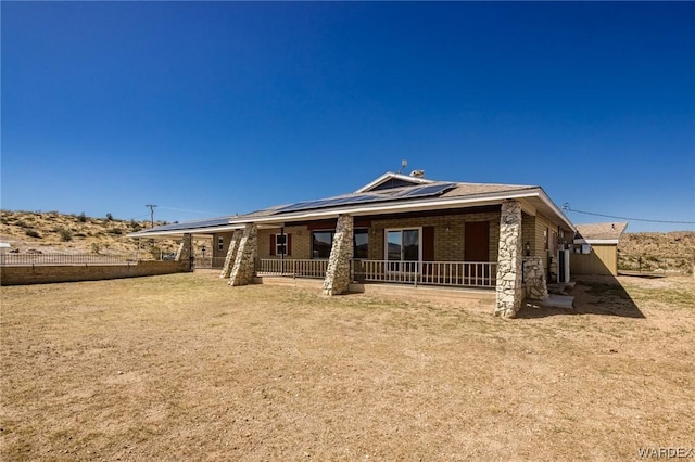 view of front of house featuring solar panels, brick siding, and stone siding