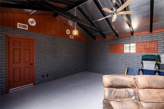 unfurnished room featuring lofted ceiling with beams, ceiling fan, brick wall, and visible vents