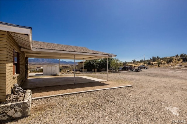 view of yard featuring a patio area, an outdoor structure, and a shed