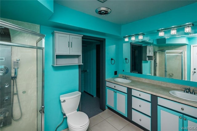 bathroom with double vanity, a stall shower, a sink, and tile patterned floors