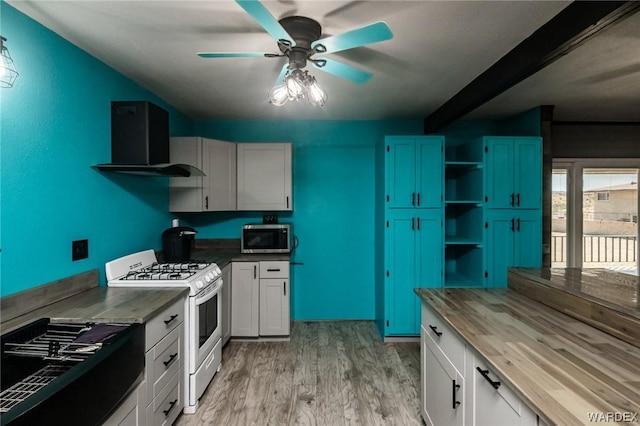 kitchen featuring butcher block counters, stainless steel microwave, white gas range, and white cabinetry