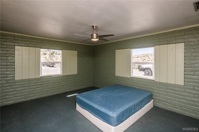 unfurnished bedroom featuring ceiling fan, multiple windows, dark colored carpet, and a textured ceiling