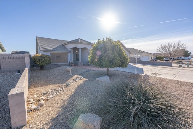 ranch-style home featuring fence and stucco siding