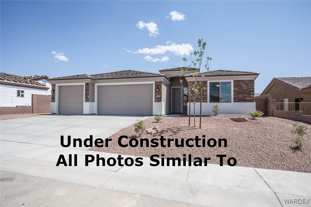 prairie-style home featuring driveway, an attached garage, and stucco siding