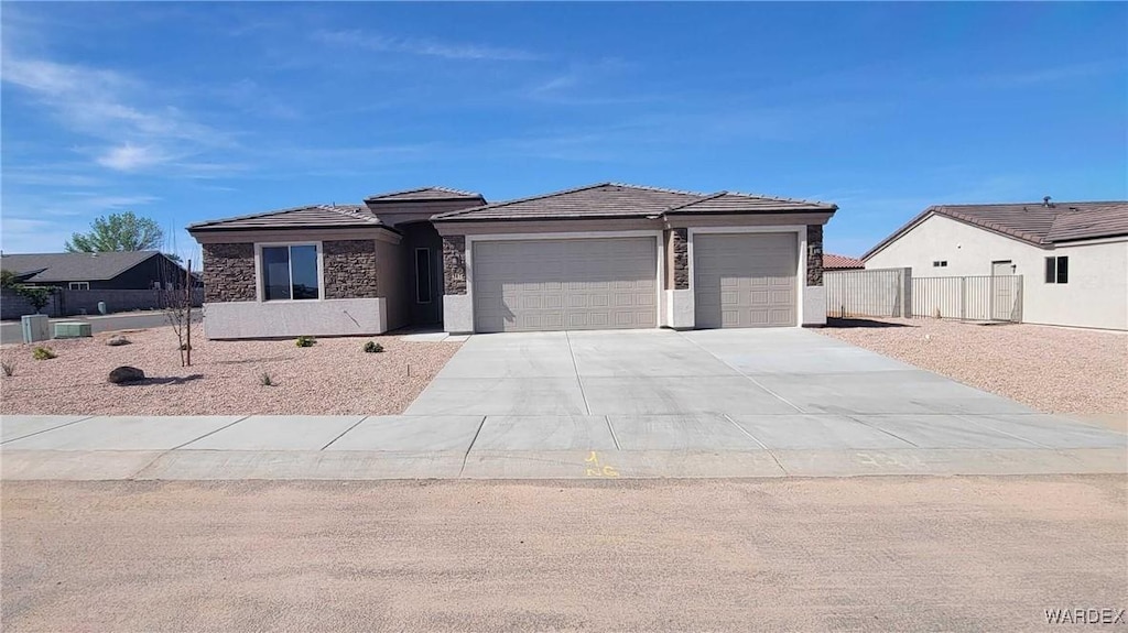 3381 E Double O Dr, Kingman, AZ 86409 - prairie-style house with stucco siding, an attached garage, fence, and driveway