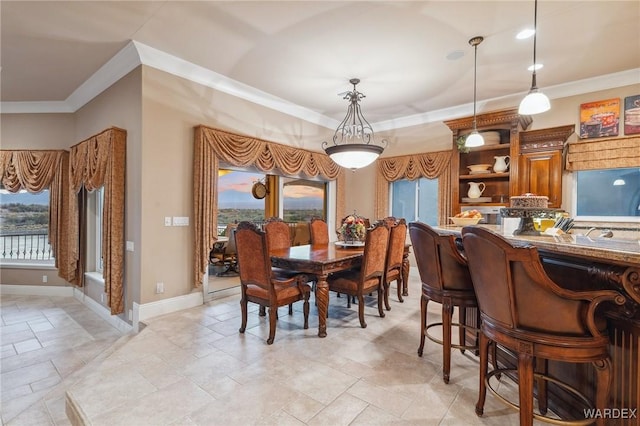 dining area with baseboards and crown molding