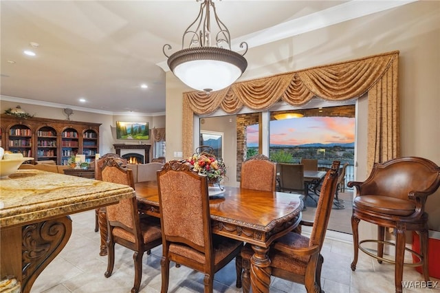 dining space featuring ornamental molding, recessed lighting, a warm lit fireplace, and light tile patterned floors