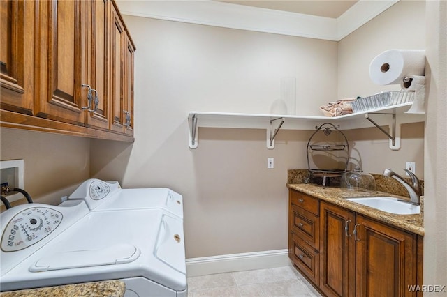 laundry area with cabinet space, baseboards, washing machine and clothes dryer, crown molding, and a sink