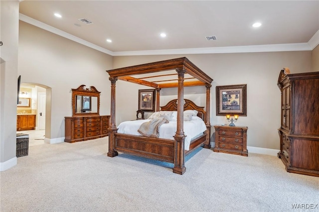 bedroom featuring arched walkways, visible vents, and light carpet