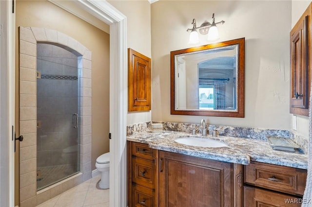 bathroom featuring a stall shower, vanity, toilet, and tile patterned floors