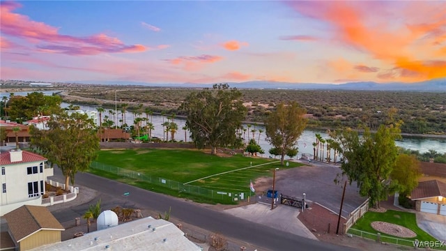 aerial view at dusk featuring a water view