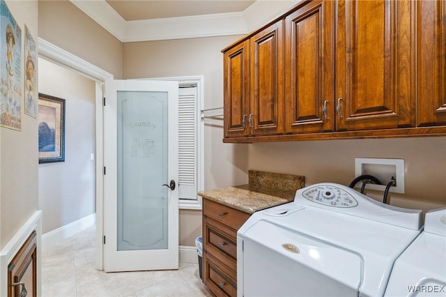 clothes washing area featuring light tile patterned flooring, washing machine and dryer, baseboards, ornamental molding, and cabinet space