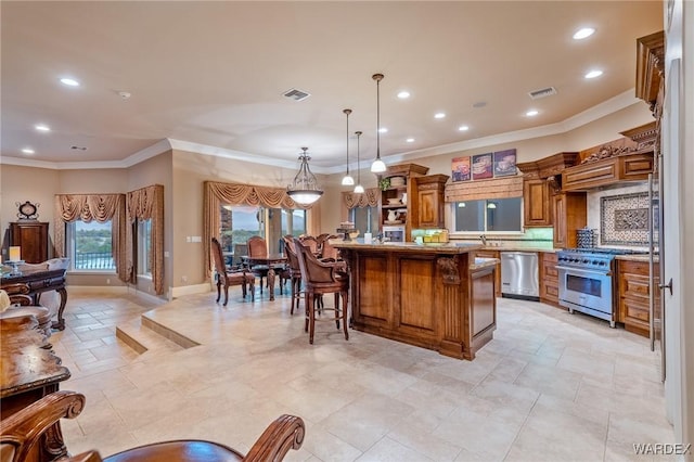 kitchen with visible vents, a kitchen island, appliances with stainless steel finishes, and a kitchen breakfast bar