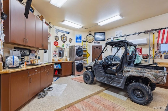 garage featuring a wall unit AC and stacked washing maching and dryer