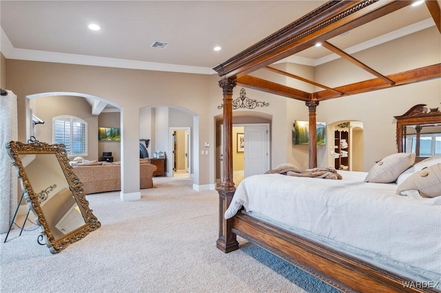 bedroom with arched walkways, light colored carpet, visible vents, ornamental molding, and baseboards