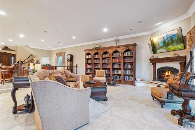 living room featuring ornamental molding, recessed lighting, a lit fireplace, and stairs