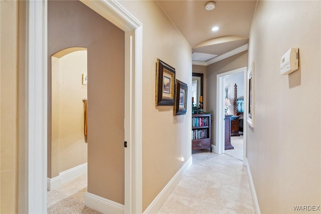 hall with arched walkways, light tile patterned floors, recessed lighting, ornamental molding, and baseboards