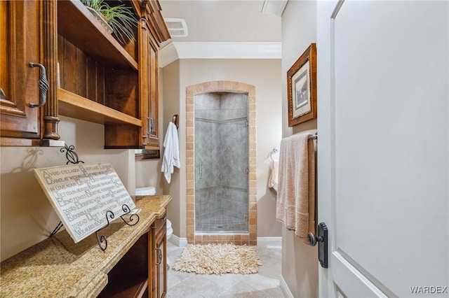 bathroom featuring a shower stall, baseboards, crown molding, and tile patterned floors