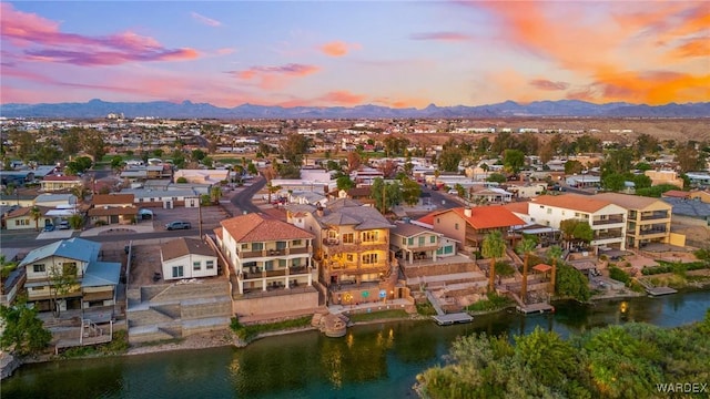 aerial view at dusk featuring a residential view and a water and mountain view