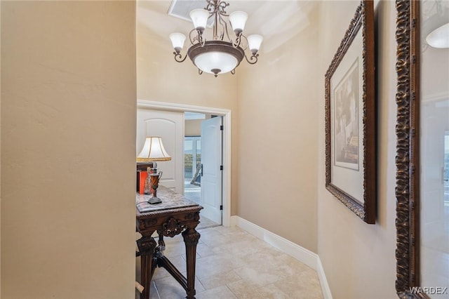 corridor featuring a chandelier and baseboards