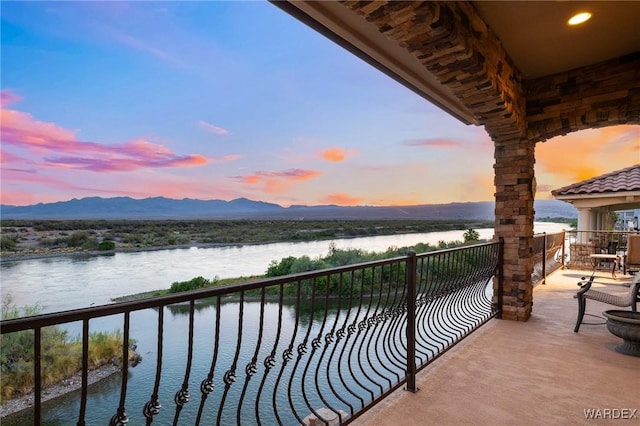 balcony featuring a water and mountain view