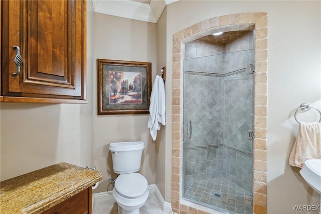 bathroom with toilet, ornamental molding, a stall shower, baseboards, and tile patterned floors