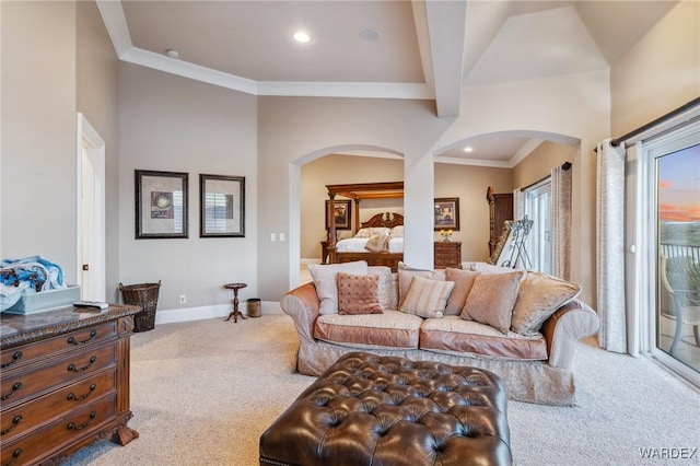 living room featuring ornamental molding, arched walkways, light carpet, and baseboards