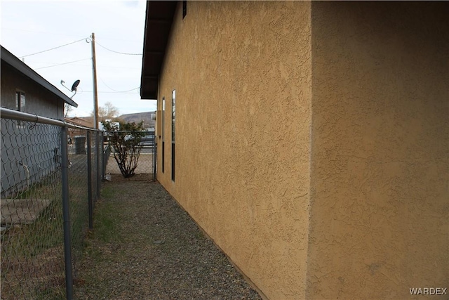 view of property exterior featuring fence and stucco siding