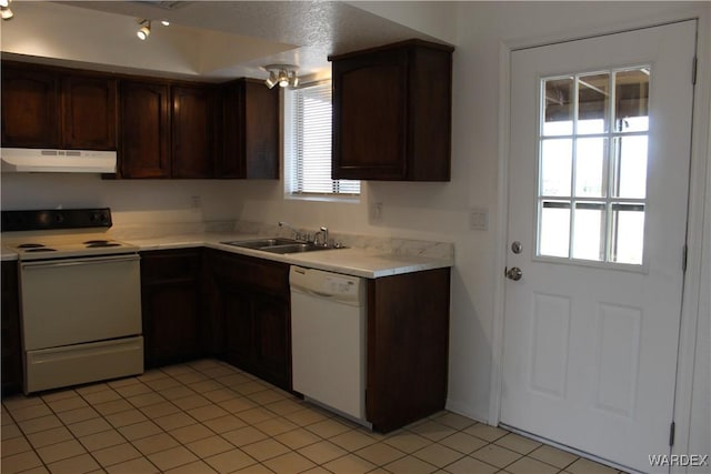 kitchen featuring light countertops, a sink, dark brown cabinets, white appliances, and under cabinet range hood