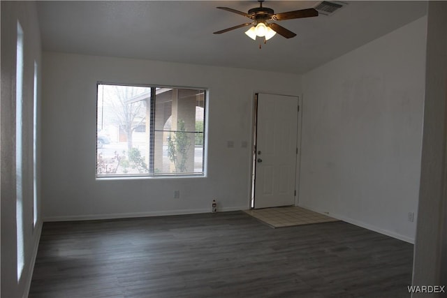 empty room featuring baseboards, wood finished floors, visible vents, and a ceiling fan