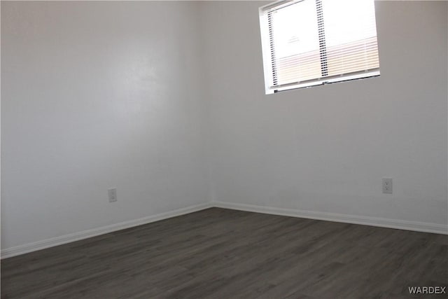 empty room with baseboards and dark wood finished floors