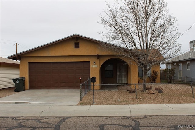 ranch-style home featuring driveway, a fenced front yard, an attached garage, and stucco siding