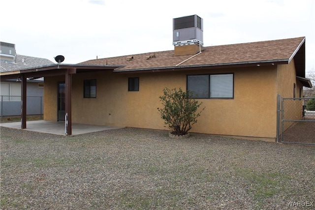 back of house with a patio, a shingled roof, fence, and stucco siding