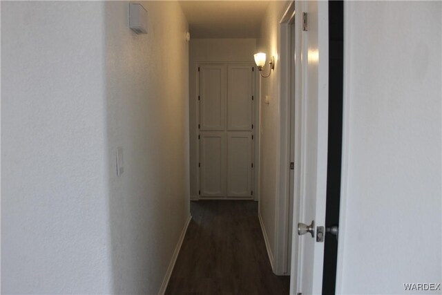 hallway with dark wood-style floors and baseboards