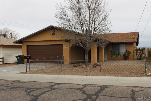 ranch-style home with driveway, a fenced front yard, an attached garage, and stucco siding