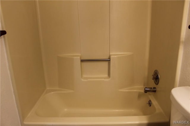 bathroom with washtub / shower combination and toilet