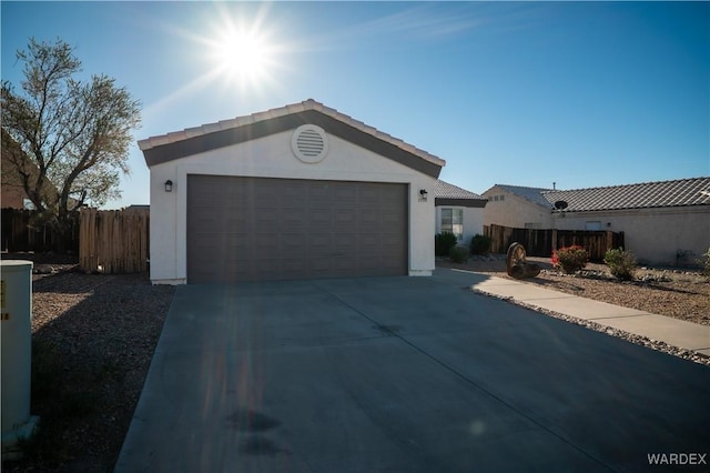 ranch-style house featuring a garage, concrete driveway, fence, and stucco siding