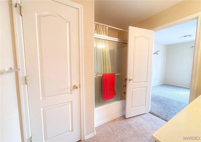 bathroom with shower / bath combination with glass door, tile patterned flooring, and visible vents