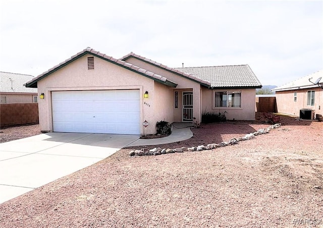 single story home with an attached garage, a tiled roof, concrete driveway, and stucco siding