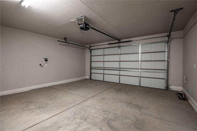 garage featuring a garage door opener and baseboards