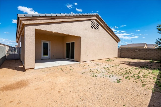 back of property featuring a patio, stucco siding, and fence