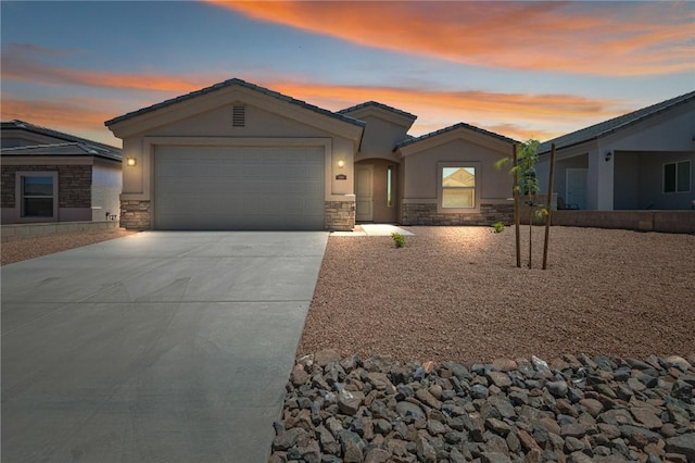 ranch-style home with stone siding, driveway, stucco siding, and an attached garage