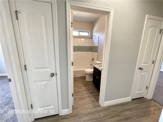 3371 N Apache St, Kingman, AZ 86401 - bathroom with wood finished floors, vanity, washtub / shower combination, and baseboards